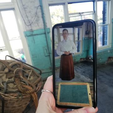 App showing a Victorian schoolteacher in a room
