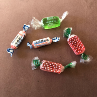 5 wrapped lollies on brown background
